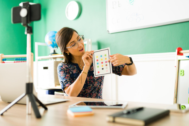 A woman recording influencer content on a mobile standing on a tripod